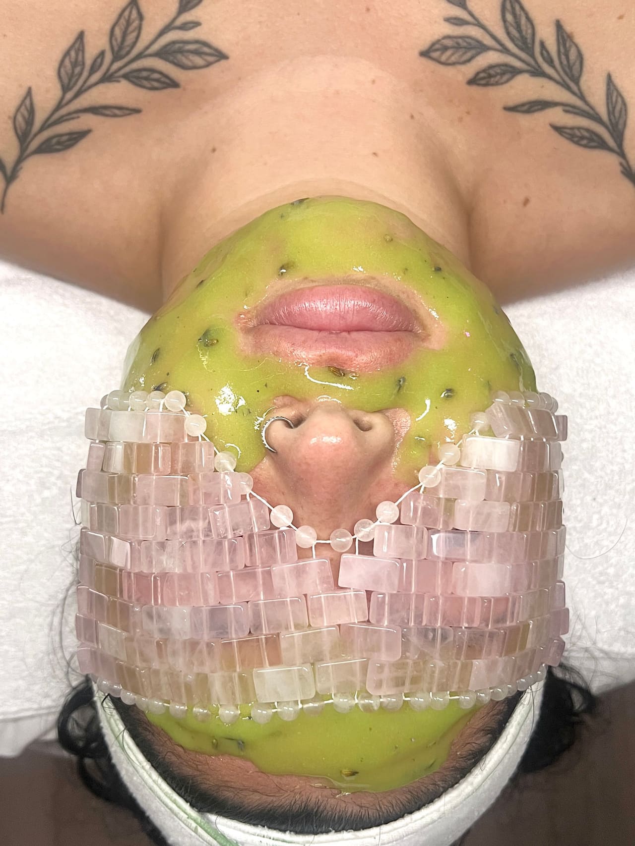 A green enzyme mask and rose quartz face mask applied during a custom facial