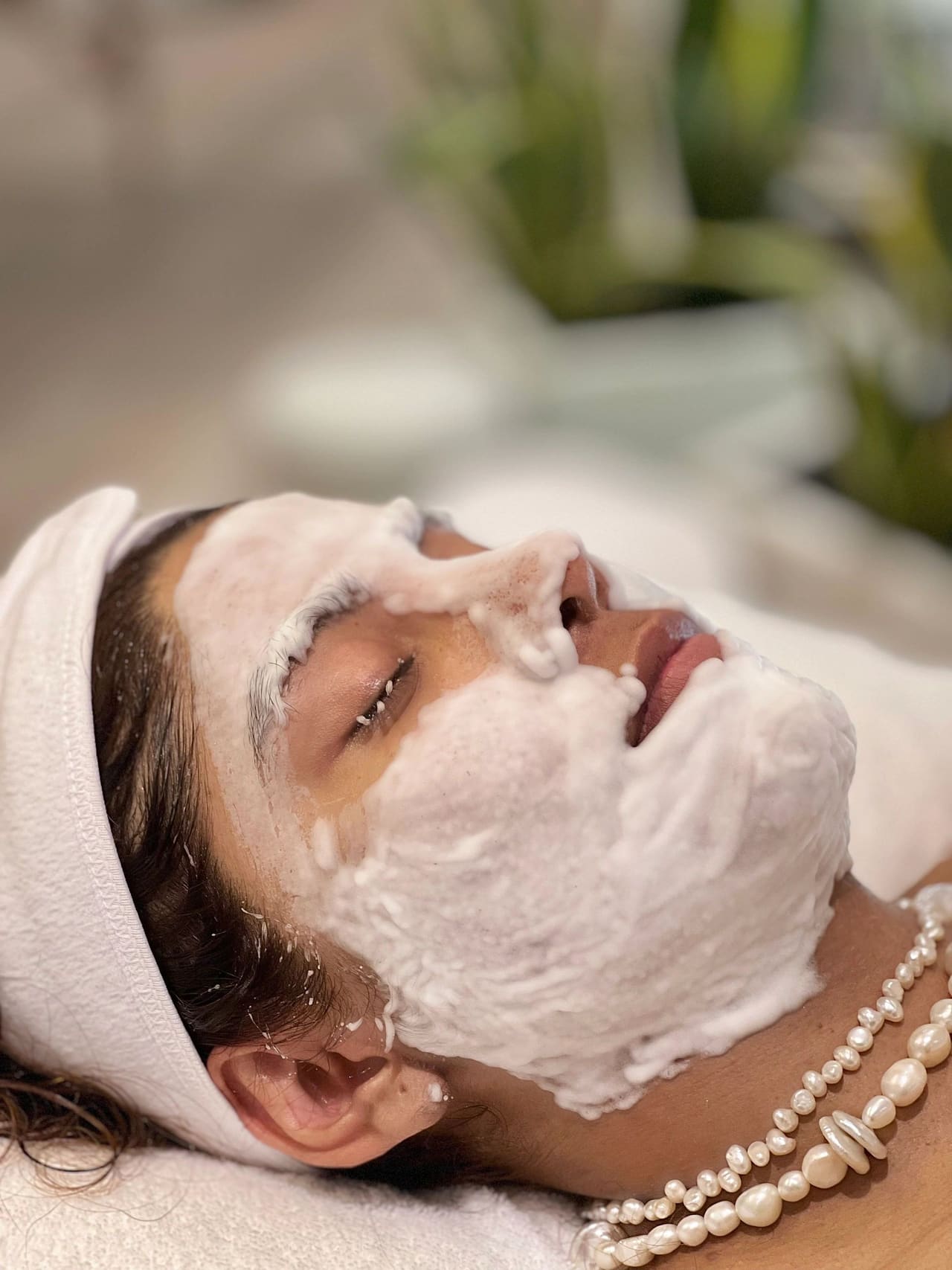 A foaming cleanser worked over a client’s face during the cleansing step of a facial